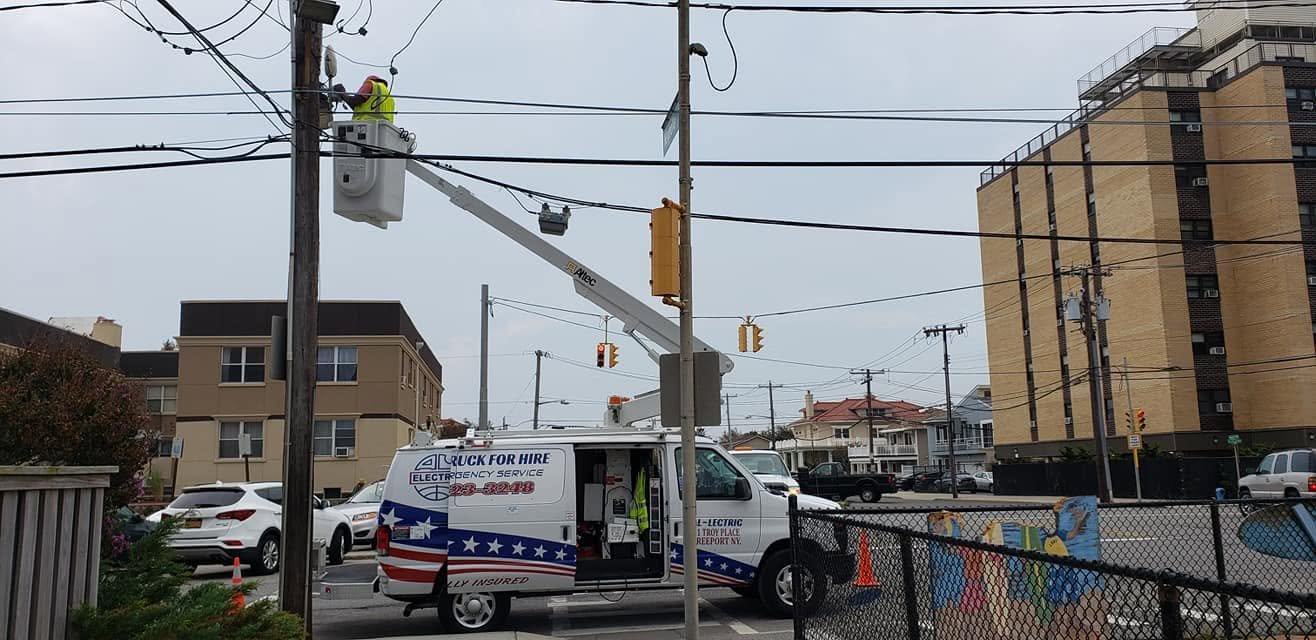 Operator in the bucket at a pole with traffic signals, beside apartment buildings