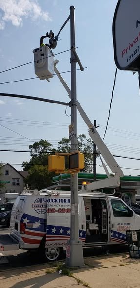 Bucket raised to a street light on a pole with a traffic signal at a city intersection