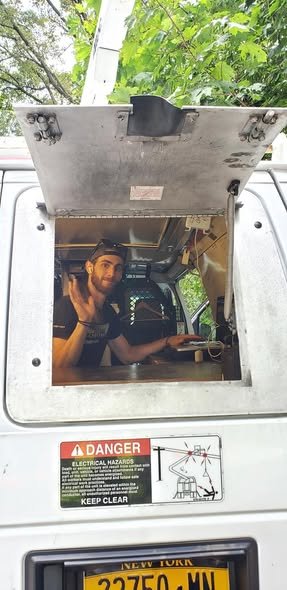 Our operator smiling and waving through the open hatch of the bucket van
