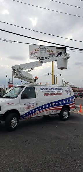 Bucket raised to a tall business sign on a pole beside our wrapped van